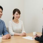 結婚相談所で相談する日本人カップルと女性カウンセラー